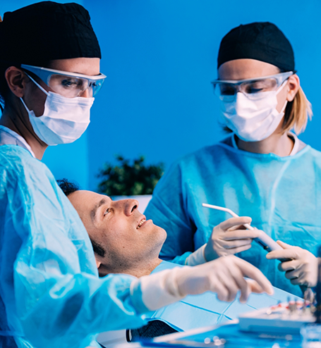 Dentists with masks treating male patient