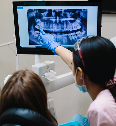 Showing patient X-ray of teeth on monitor