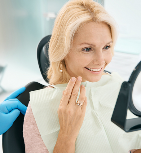 Female patient checking smile in mirror